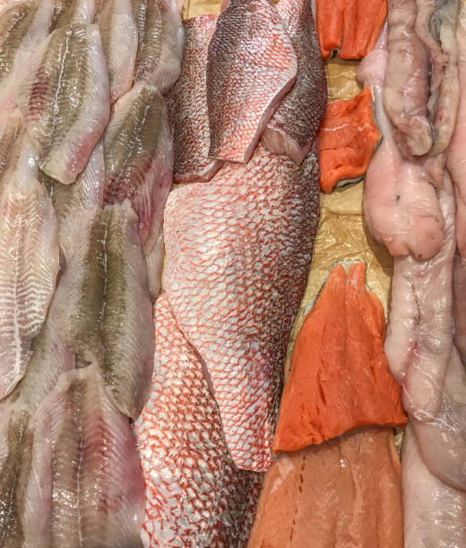 Fish on display offered for sale Cut fish for sale at on a counter at a supermaket. salmon and red snapper stock pictures, royalty-free photos & images