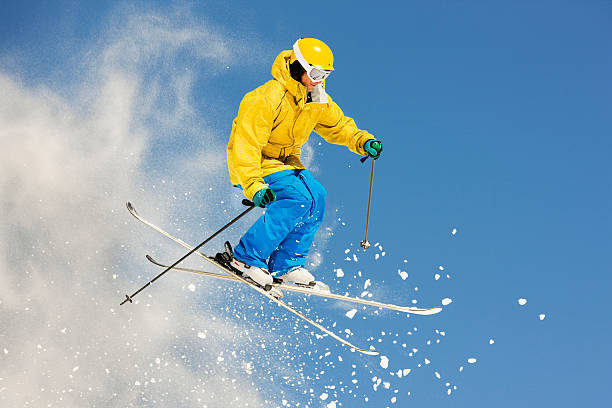 Skier Suspended In Mid-Air Against Blue Sky stock photo