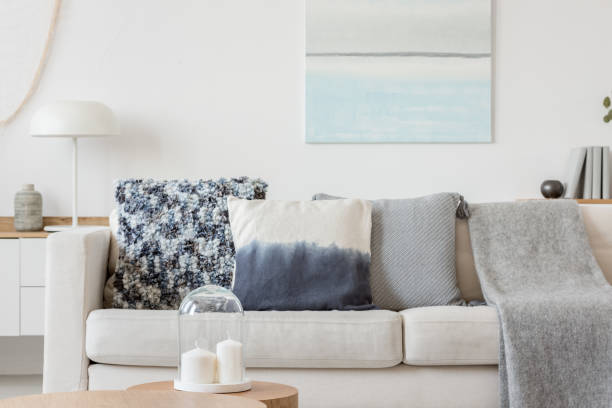istock Abstract paste blue and white painting on empty white wall behind beige couch with pillows 1180795151