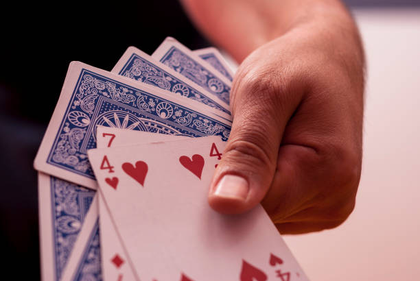 Una mano che tiene le carte da poker - foto stock