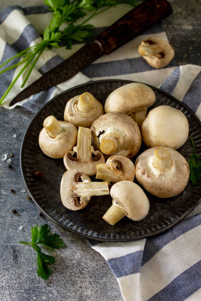 istock Mushrooms. Fresh white mushrooms in bowl on stone background. 1180798344