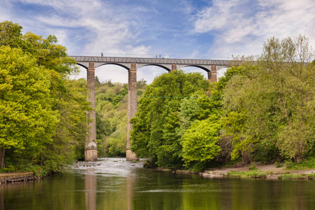 Pontcysyllte Aqueduct, Llangollen, Wales, UK Pontcysyllte Aqueduct, built by Thomas Telford, and a World Heritage Site, reflecting in the River Dee, with incidental people walking across, near Llangollen, County Borough of Wrexham, Wales, UK borough district type photos stock pictures, royalty-free photos & images