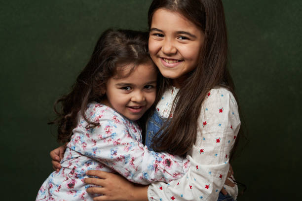 istock Two sisters portrait on green background with copy space 1180800969