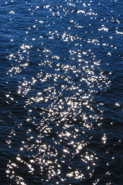 istock sun sparkles in blue water. Abstract background with space for text 1180801341