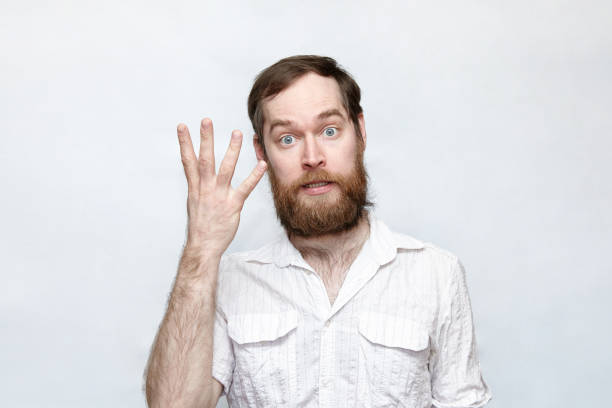 istock Bearded man showing four fingers over gray background 1180802371