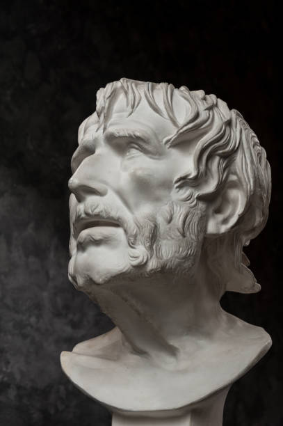 istock Gypsum copy of ancient statue Seneca head on dark textured background. Plaster sculpture man face. 1180802424
