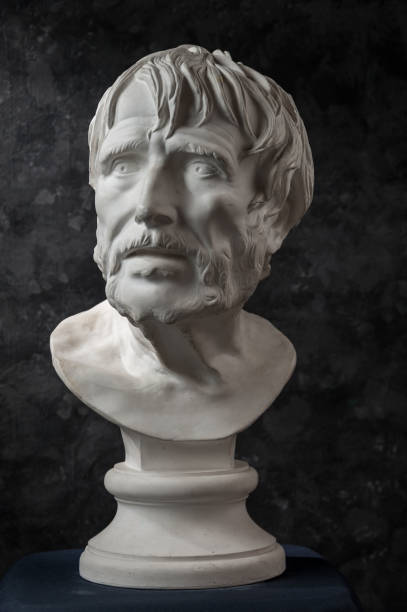 istock Gypsum copy of ancient statue Seneca head on dark textured background. Plaster sculpture man face. 1180802486