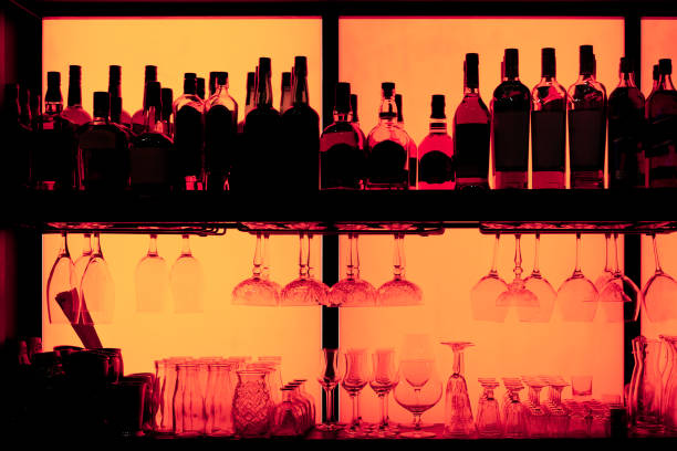 istock Bottles and glasses sitting on shelf in a bar, trade marks removed 1180803669