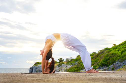 Woman Yoga. Woman practice meditation at the coast. Relex in nature.