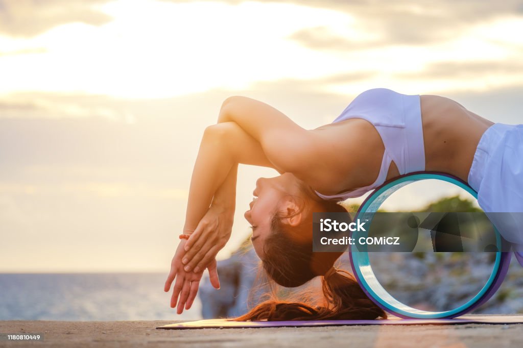 Relax in Nature Yoga with wheel. Woman Yoga. Woman practice meditation at the coast. Relex in nature. Yoga Stock Photo