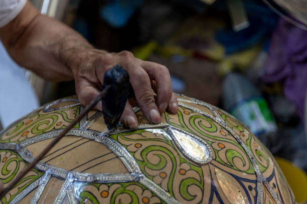istock Close-up hands applying metal outline to ceramic bowl 1180810572