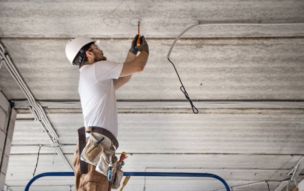istock Electrician installer with a tool in his hands, working with cable on the construction site. 1180814615