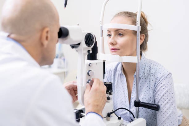 istock Young female looking at ophthalmologist while having her eyesight examined 1180815547