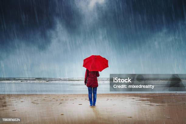 Woman In The Rain Stock Photo - Download Image Now - Rain, Umbrella, Beach