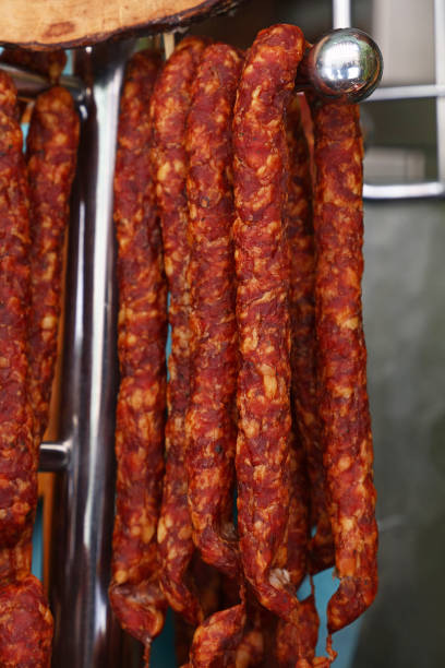 istock Cured smoked red meat sausages hanging in store 1180819341