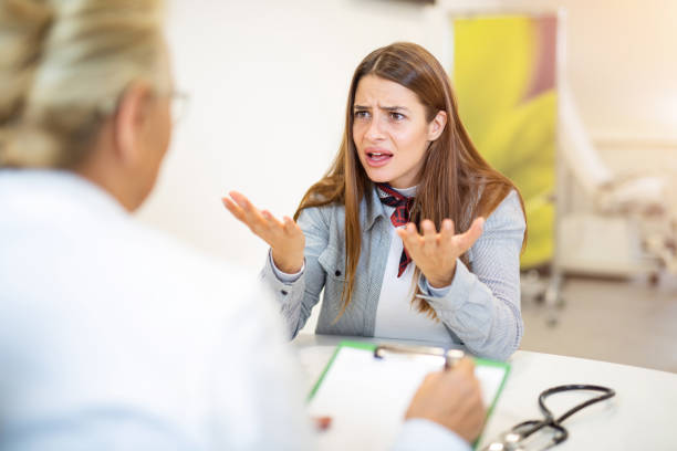 jeune femme frustrée parlant avec son docteur. - colère photos et images de collection