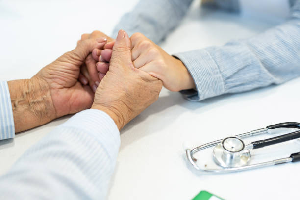 istock Supportive female doctor and patient holding hands close-up. 1180820422