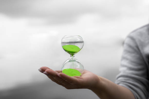 istock green hourglass against a blurred background in nature 1180828246