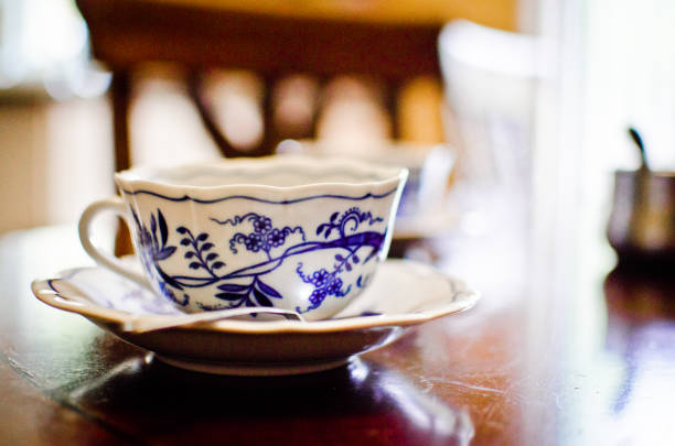 Close up image of stacked teacups in front of a window