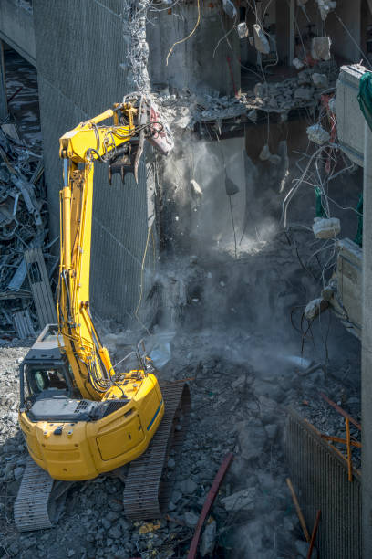 istock Demolishing building with heavy machinery 1180833273