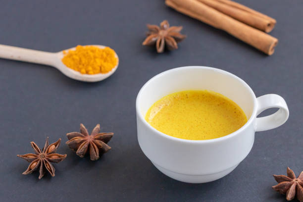 istock Golden (turmeric) milk in a white cup on the dark background. 1180833415