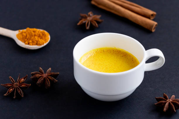 istock Golden (turmeric) milk in a white cup on the dark background. 1180833438