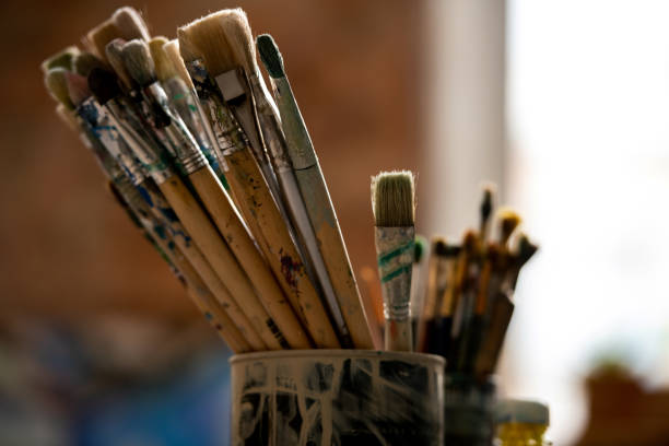 istock Set of paintbrushes for professional painting in tin can inside modern studio 1180833595