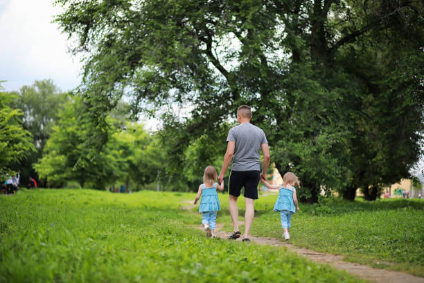 istock Mom with two daughters twins 1180834296