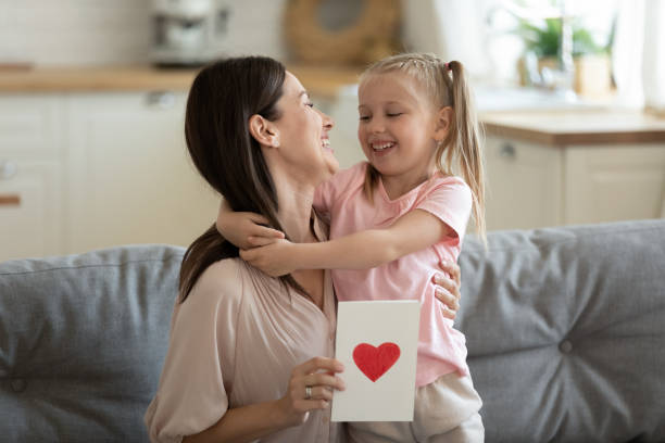 istock Happy mother hugging little daughter, thanking for gift postcard 1180835006