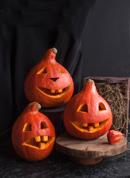 istock Three pumpkins with carved funny faces for Halloween party. 1180836670