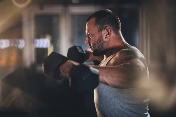 istock Muscular man doing exercises with dumbbells 1180836856
