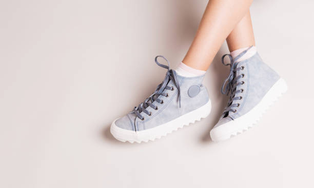 sneakers blu pastello su gambe incrociate - calzature casual - girl casual foto e immagini stock