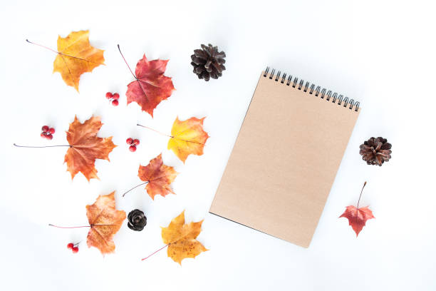 istock Autumn composition with empty craft notebook and autumn leaves on a white background, flat lay 1180839916