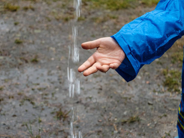 Child's palm in the water flow during the rain. stock photo
