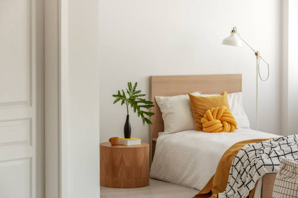 istock Yellow pillows and blanket on white single wooden bed 1180843178