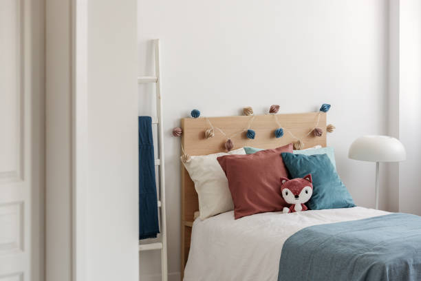 istock Toy fox and blue and ginger pillows on single bed in white bedroom interior for kid 1180843184