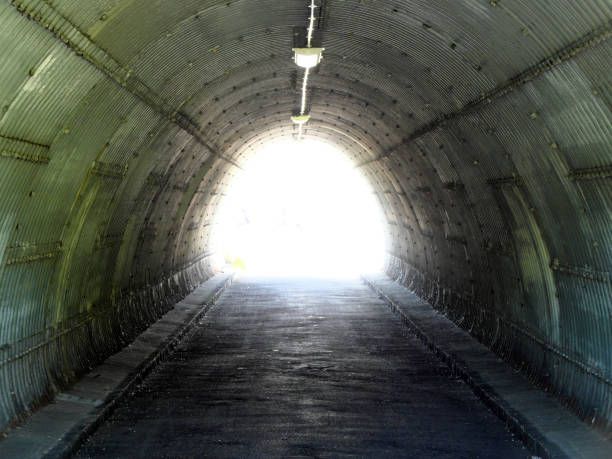 un tunnel avec la lumière à l'en de celui-ci. le concept d'espoir à la fin des temps sombres. - spirituality light tunnel light at the end of the tunnel photos et images de collection