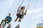 Below view of happy woman having fun on chain swing ride.