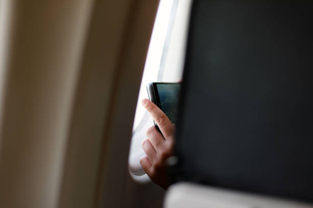 istock Hands taking a picture on an airplane 1180844630