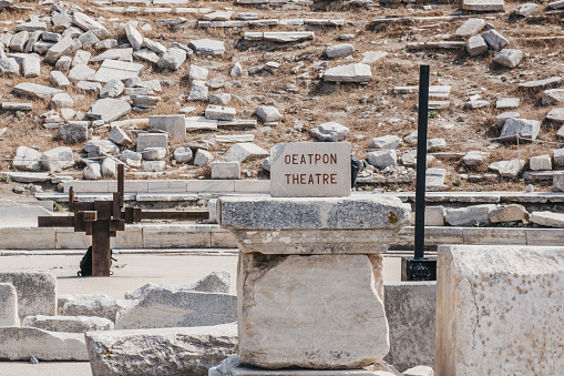 Sign at the outdoor ancient theatre on the Greek island of Delos, archaeological site near Mykonos in the Aegean Sea Cyclades archipelago. Selective focus.