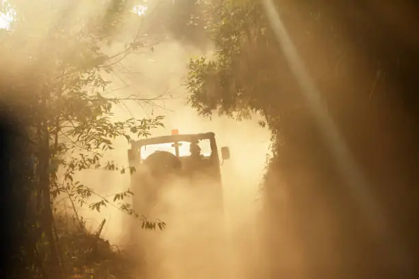 Photo of Rear view of military vehicle on dusty road.