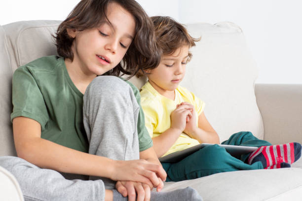 istock The brothers are playing tablet on the couch 1180848909