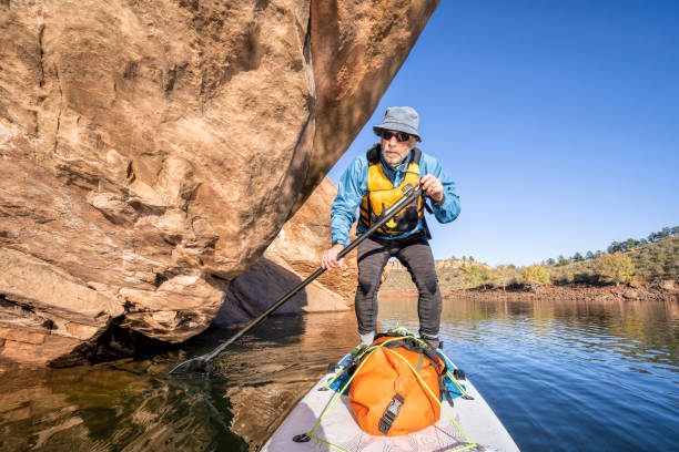 istock senior male on stand up paddleboard - POV 1180850025
