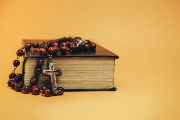 istock Holy Bible with old beads on a yellow background table. Religion concept. 1180854734