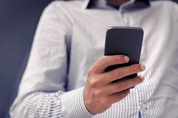 istock Unrecognizable businessman texting on cell phone. 1180854886