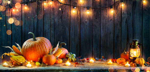 Thanksgiving - Pumpkins On Rustic Table With Candles And String Lights Thanksgiving - Pumpkins On Rustic Table With Candles And String Lights autum light stock pictures, royalty-free photos & images