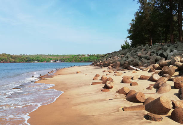 istock Sunny sandy seashore in North Goa India with city views and triangular breakwaters in the foreground 1180857964