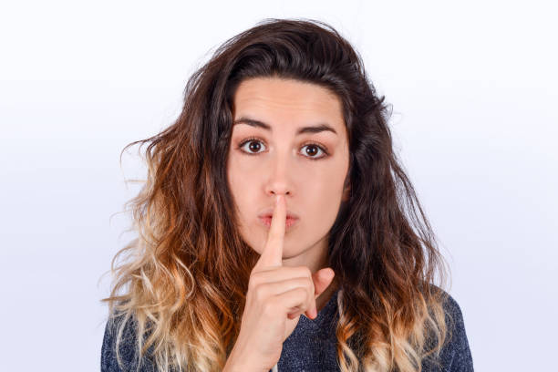 istock Close up of young woman making silence gesture. 1180859079