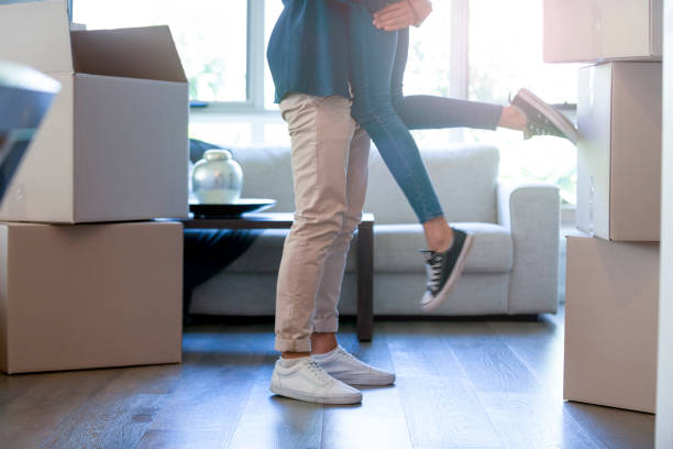 istock Couple embracing after moving into a new house. 1180860333