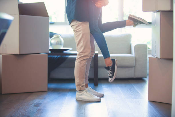 istock Couple embracing after moving into a new house. 1180860339